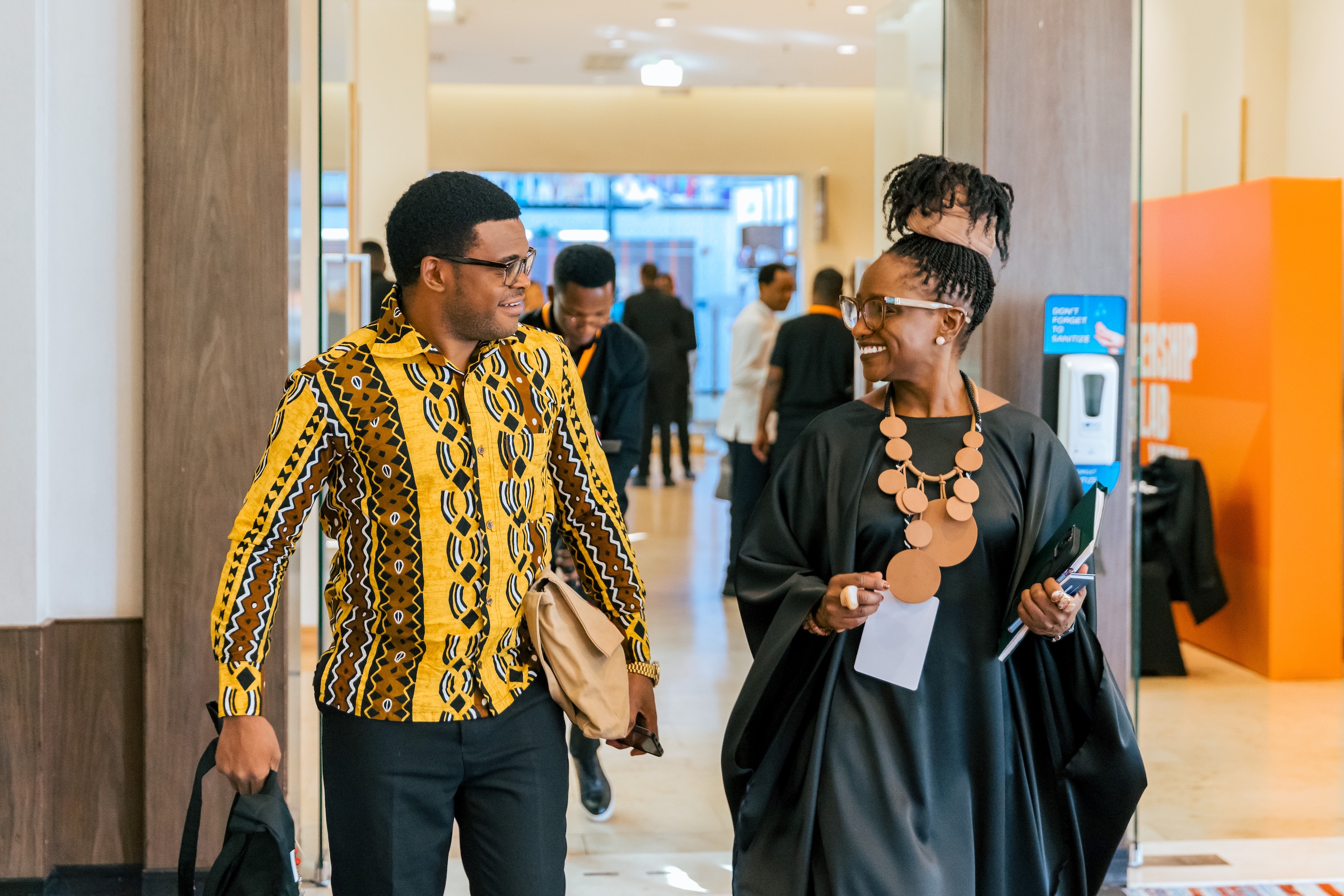 Two leaders conversing while walking down a corridor